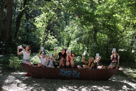 zu sehen sind Kinder im Wald die mit Tablets fotografieren und filmen